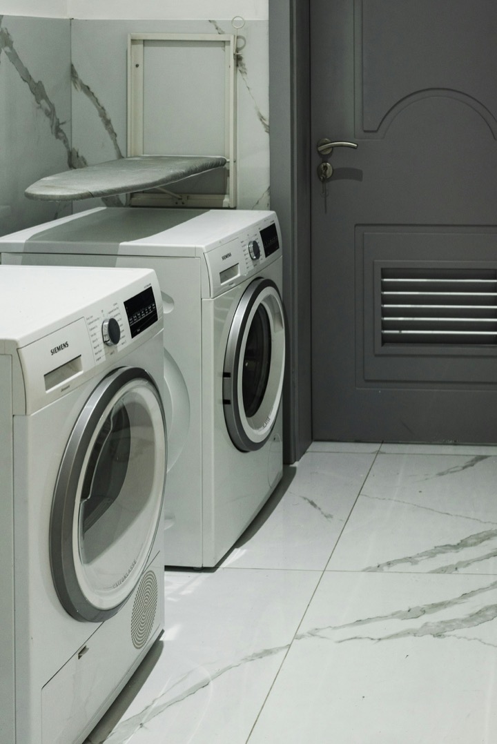 A pair of modern front-load washing machines in a laundry room